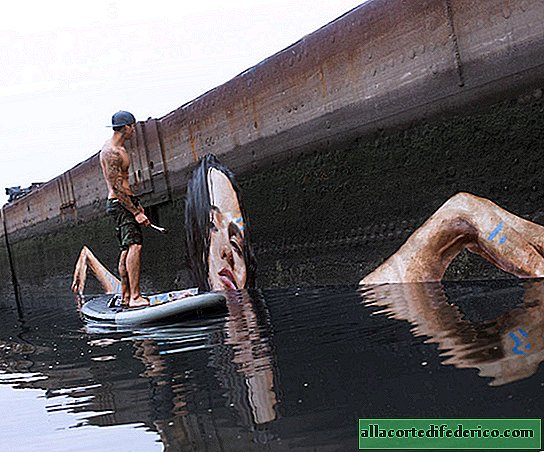 Een kunstenaar maakt prachtige watermuurschilderingen door op een surfplank te balanceren